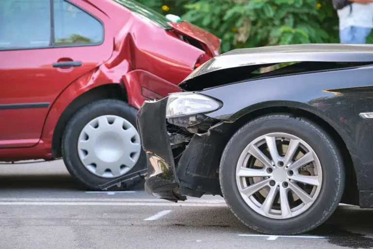 Red car crashed into parked black car